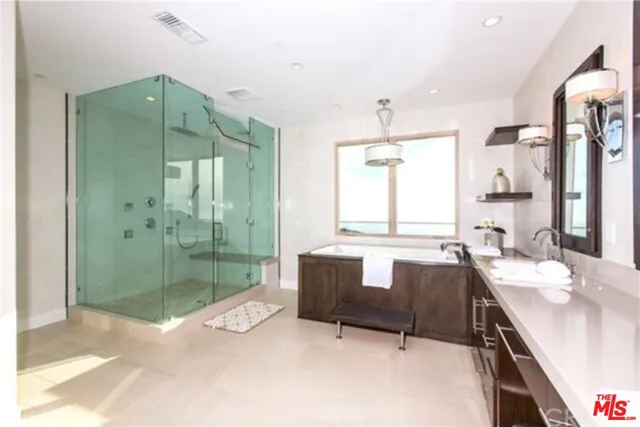 a spacious bathroom with a shower sink and mirror