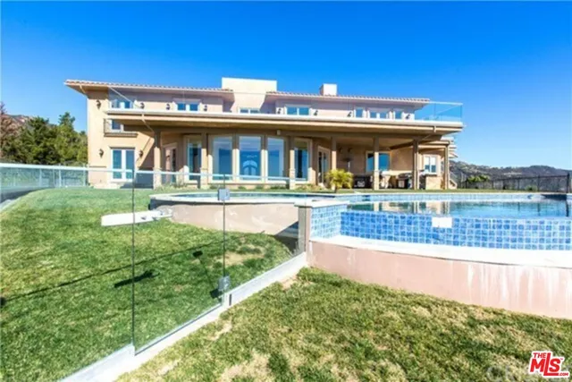 a view of a house with pool and a yard