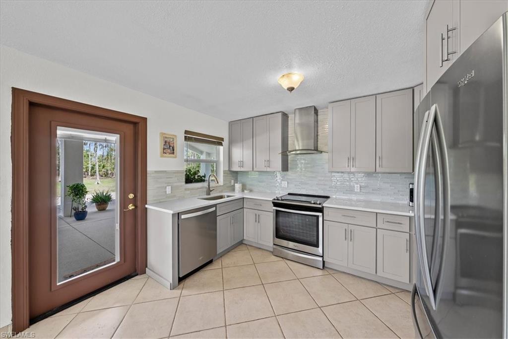 6070 Lee Williams Road Naples, FL 34117 - Photo 12 of 26 a kitchen with a stove sink and refrigerator