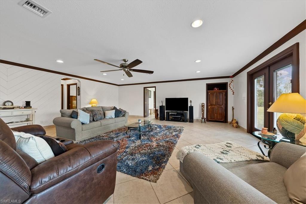 6070 Lee Williams Road Naples, FL 34117 - Photo 14 of 26 a living room with furniture and a flat screen tv