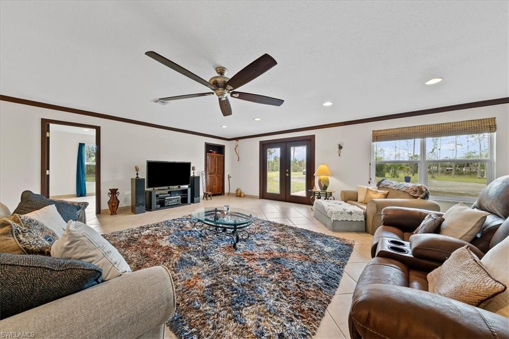 6070 Lee Williams Road Naples, FL 34117 - Photo 15 of 26 a living room with furniture and a flat screen tv