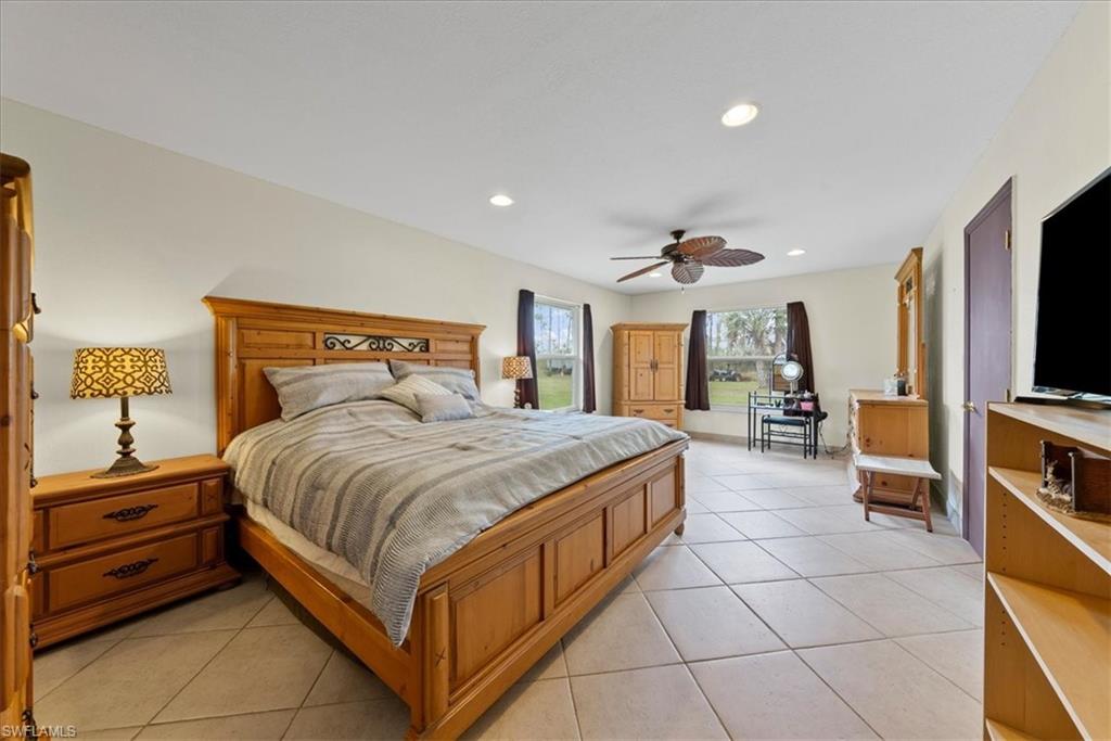 6070 Lee Williams Road Naples, FL 34117 - Photo 17 of 26 a spacious bedroom with a bed and a flat screen tv