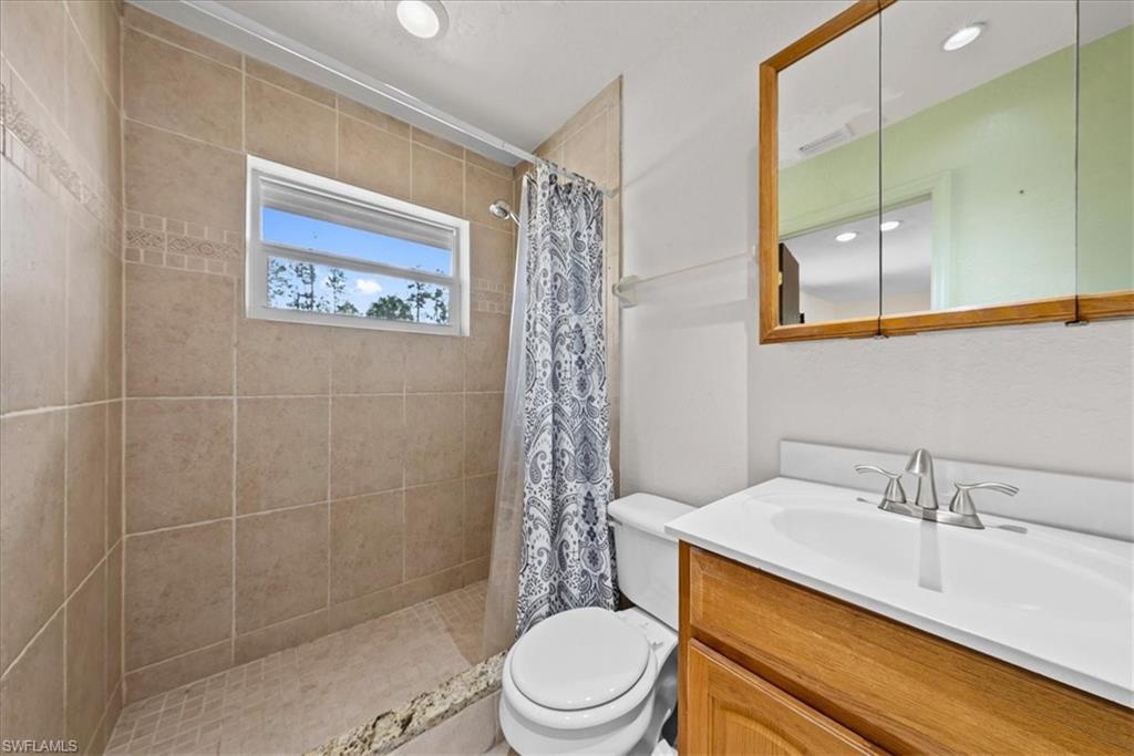 6070 Lee Williams Road Naples, FL 34117 - Photo 20 of 26 a bathroom with a sink a toilet and shower