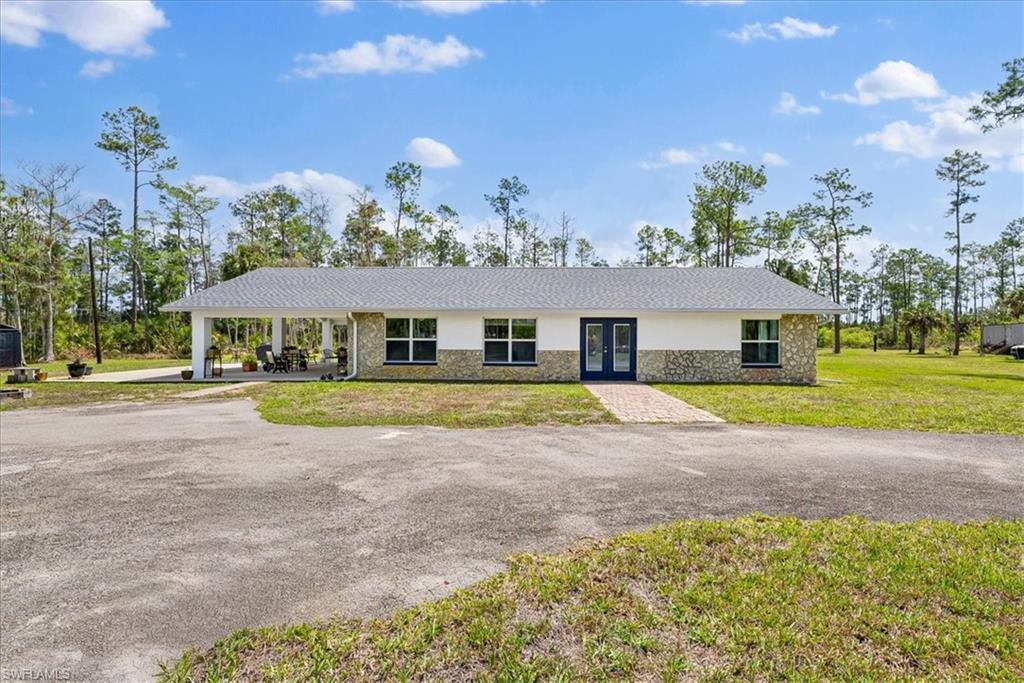 6070 Lee Williams Road Naples, FL 34117 - Photo 6 of 26 a view of a house with a big yard and large trees