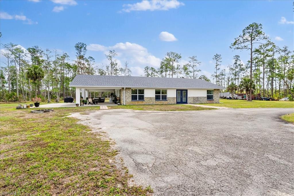 6070 Lee Williams Road Naples, FL 34117 - Photo 7 of 26 a front view of a house with a garden