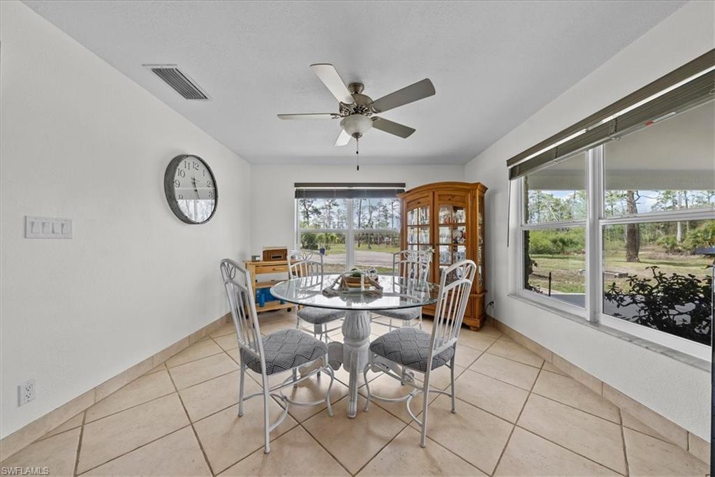 6070 Lee Williams Road Naples, FL 34117 - Photo 10 of 26 a view of a dining room with furniture wooden floor and a chandelier