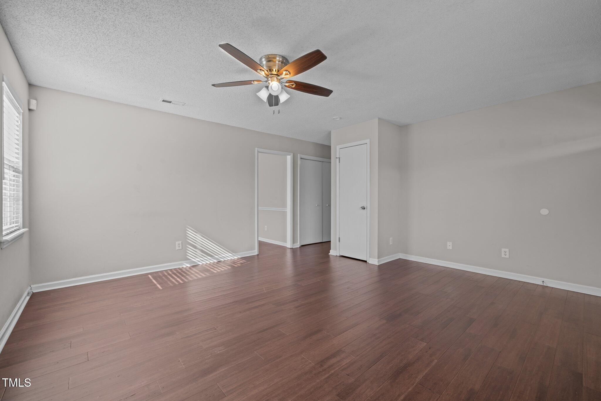 4104 Ludgate Drive Durham, NC 27713 - Photo 19 of 46 a view of an empty room with wooden floor and a ceiling fan