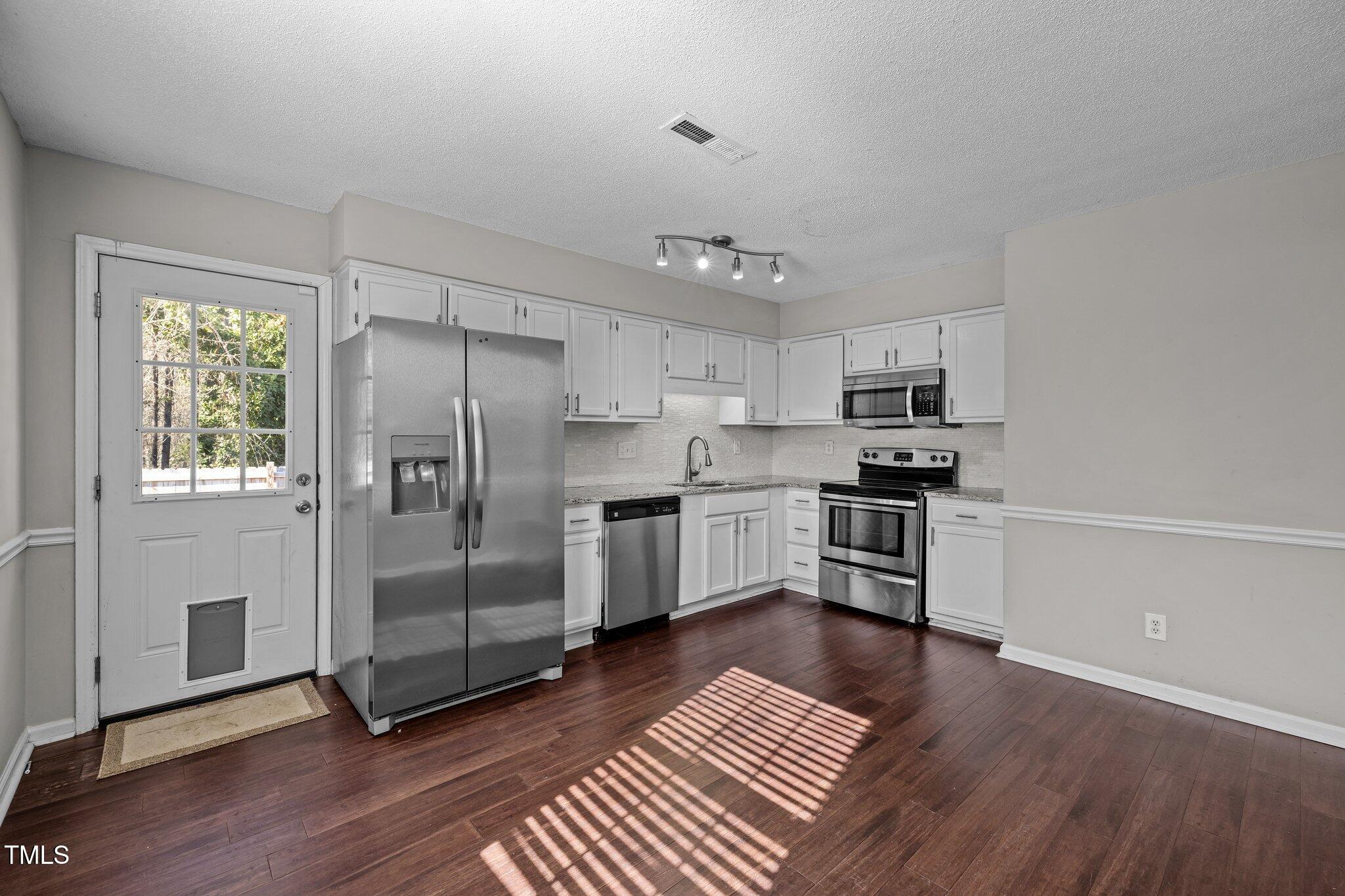 4104 Ludgate Drive Durham, NC 27713 - Photo 7 of 46 a kitchen with stainless steel appliances a refrigerator sink and microwave