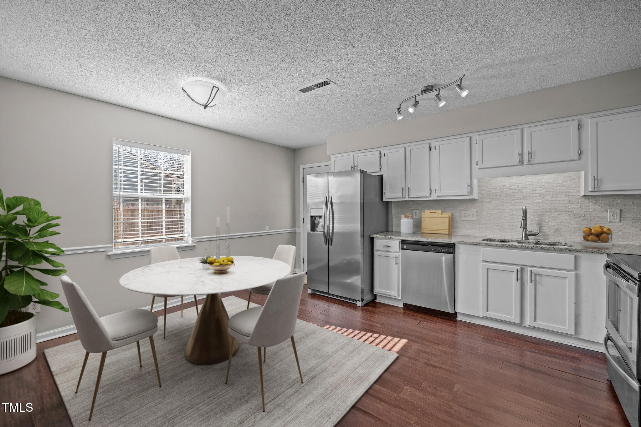 4104 Ludgate Drive Durham, NC 27713 - Photo 10 of 46 a kitchen with stainless steel appliances a dining table chairs and wooden floor