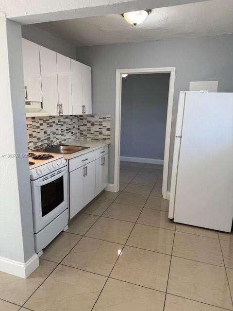 172 Northwest 12th Street, Unit 2 Miami, FL 33136 - Photo 6 of 11 a kitchen with cabinets and white appliances
