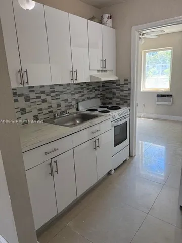 a close view of a refrigerator in kitchen and an empty room