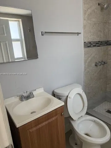 a bathroom with a granite countertop sink toilet and shower