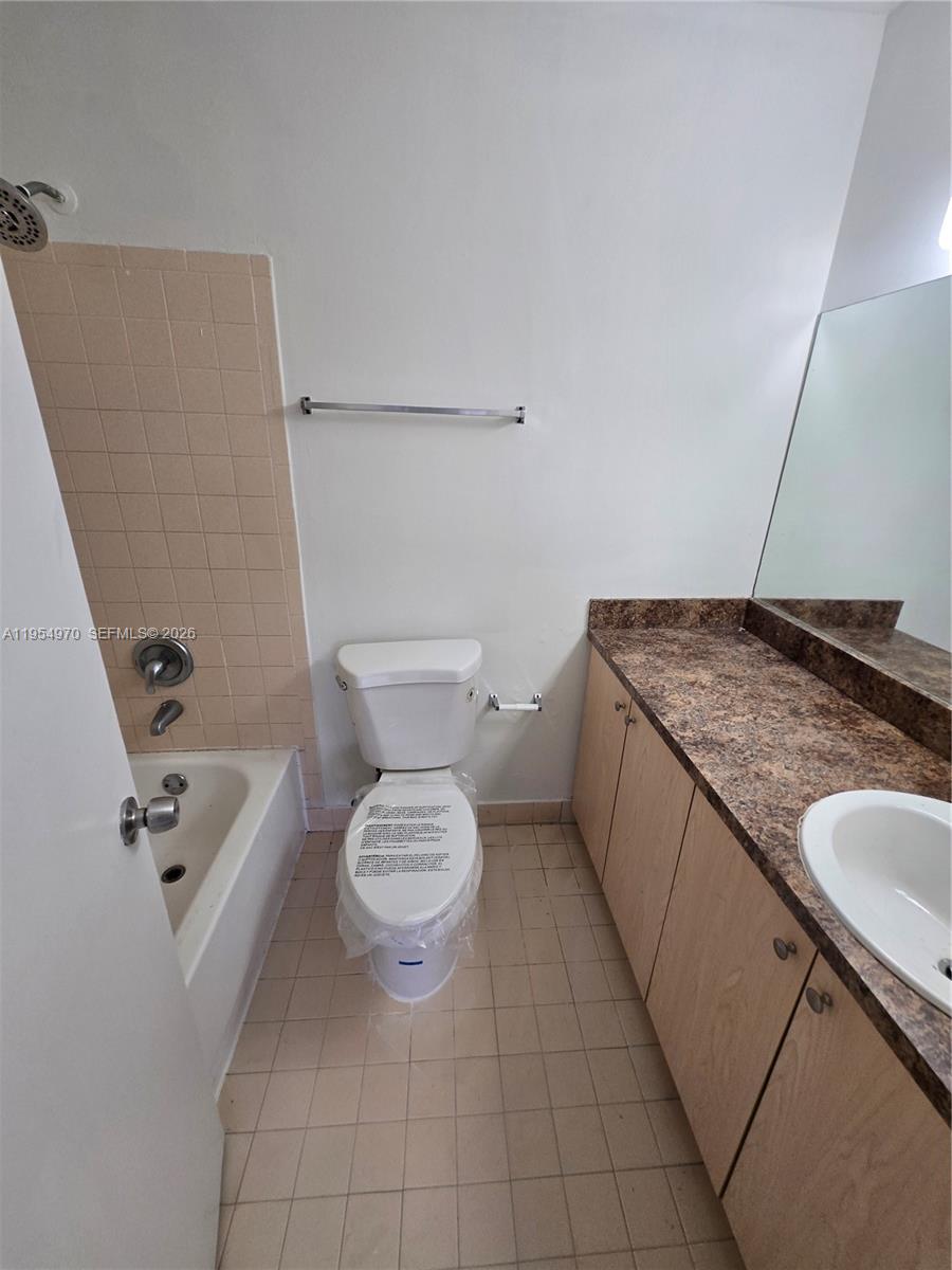 15439 Southwest 80th Street, Unit 2029 Miami, FL 33193 - Photo 15 of 16 a bathroom with a granite countertop sink and toilet