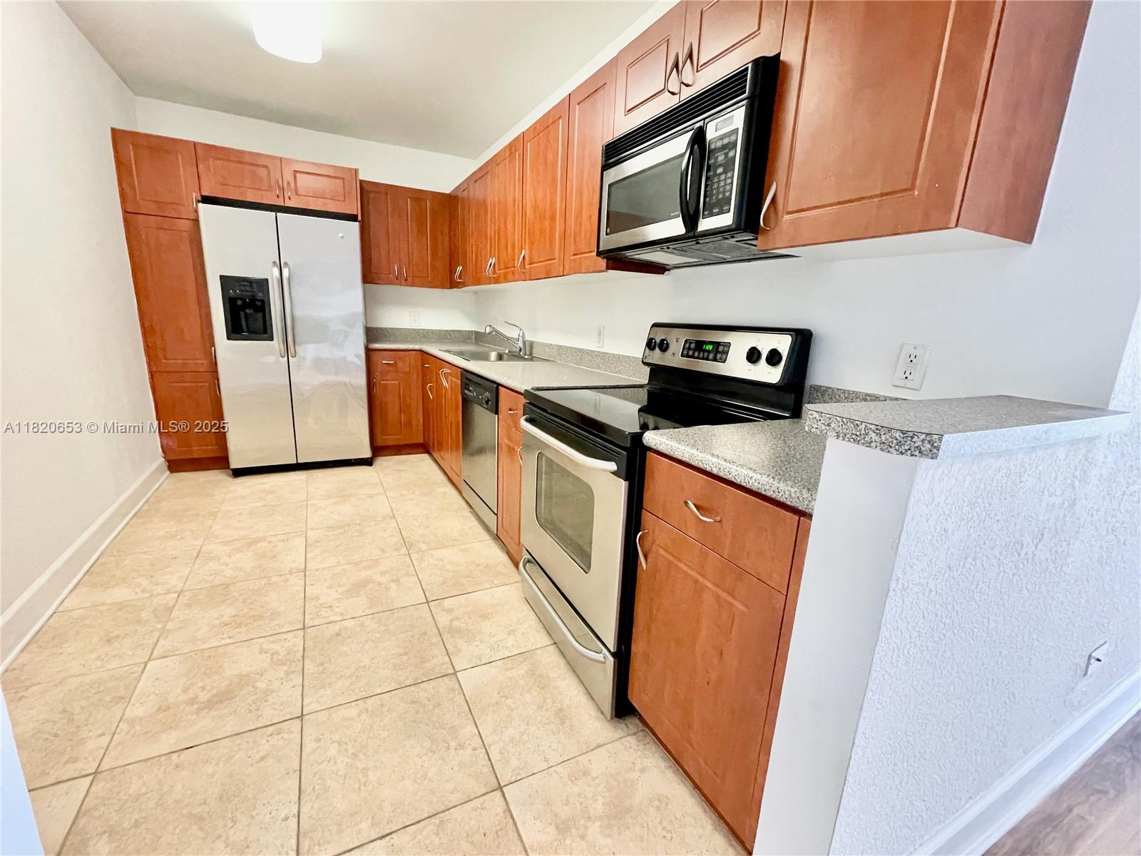 401 69th Street, Unit 405 Miami Beach, FL 33141 - Photo 2 of 25 a kitchen with stainless steel appliances granite countertop a stove a sink and a microwave