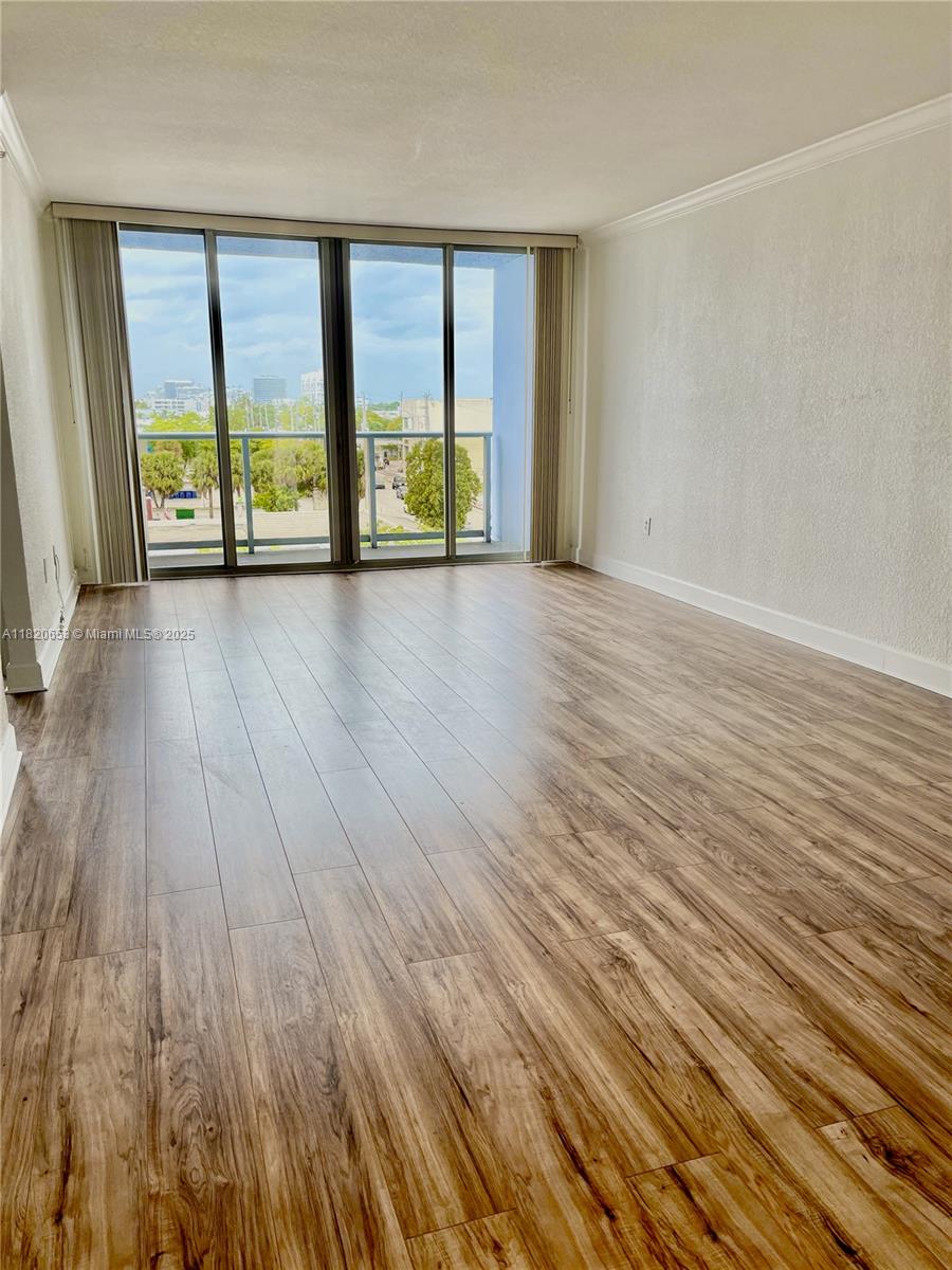 401 69th Street, Unit 405 Miami Beach, FL 33141 - Photo 5 of 25 wooden floor in an empty room with a window