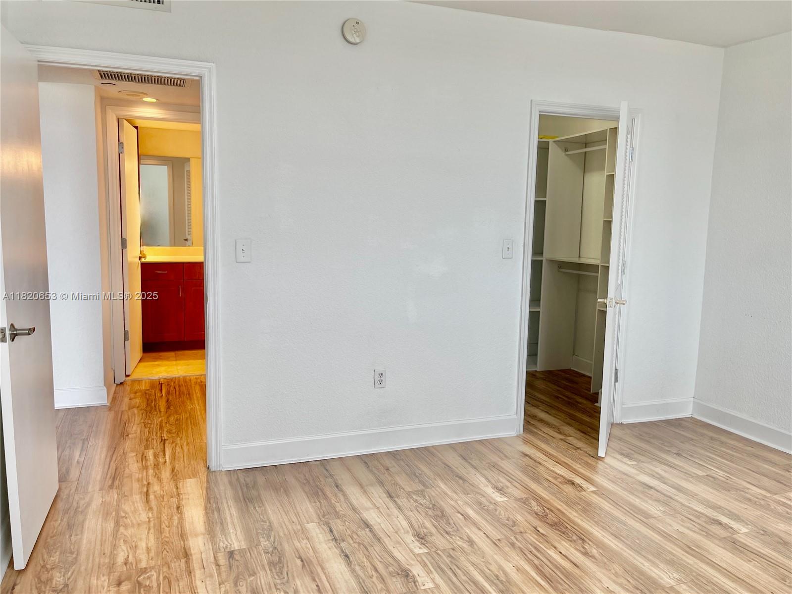 401 69th Street, Unit 405 Miami Beach, FL 33141 - Photo 9 of 25 an empty room with wooden floor and closet