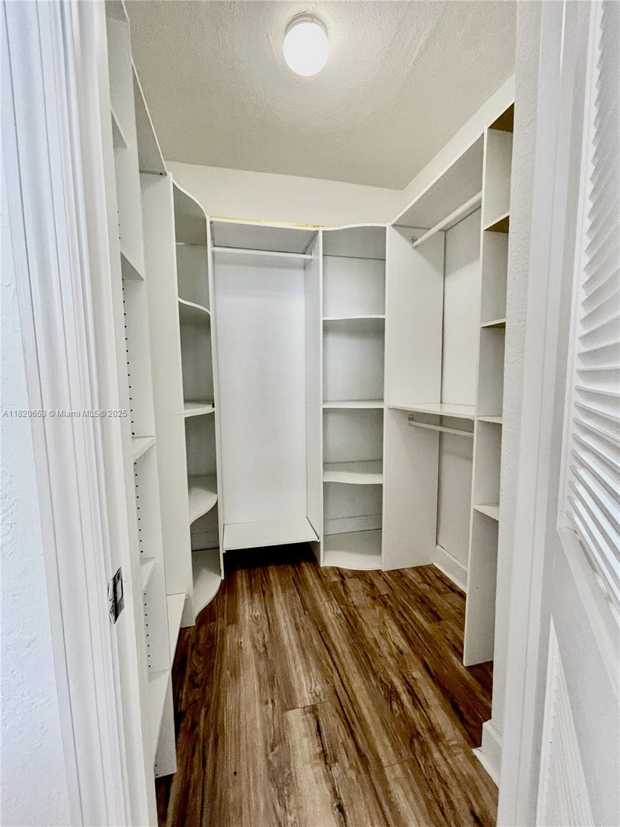 401 69th Street, Unit 405 Miami Beach, FL 33141 - Photo 10 of 25 a living room with walk in closet and wooden floor