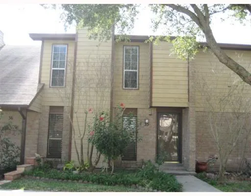 front view of a brick house with a small yard
