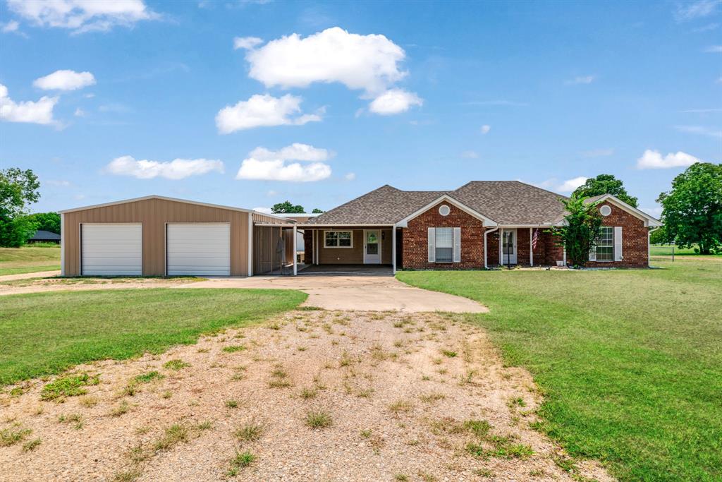 201 Farm To Market 906 Powderly, TX 75473 - Photo 33 of 37 a front view of a house with a yard and garage