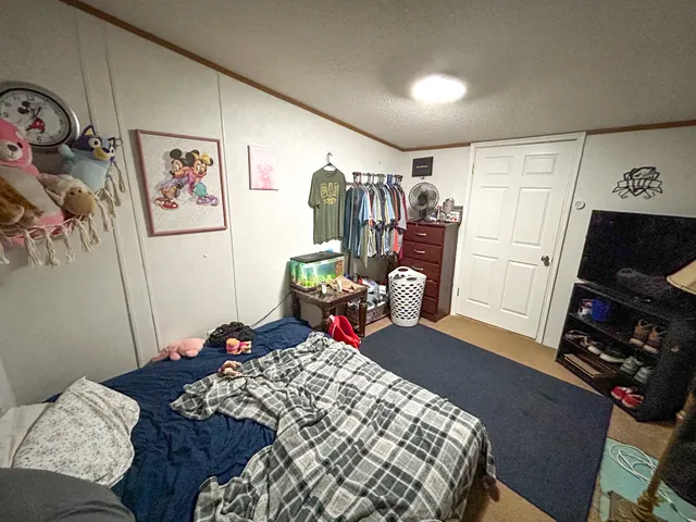 a bed sitting in a bedroom next to a window