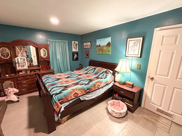 a bedroom with a bed and a mirror on dresser