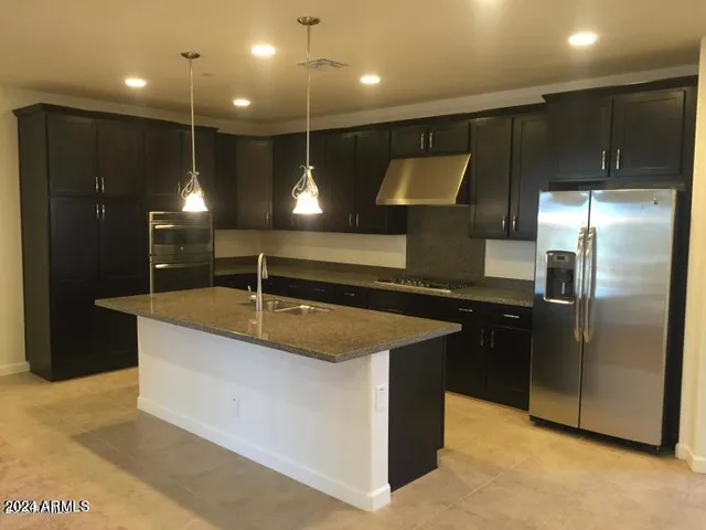 a kitchen with kitchen island a counter top space cabinets and stainless steel appliances