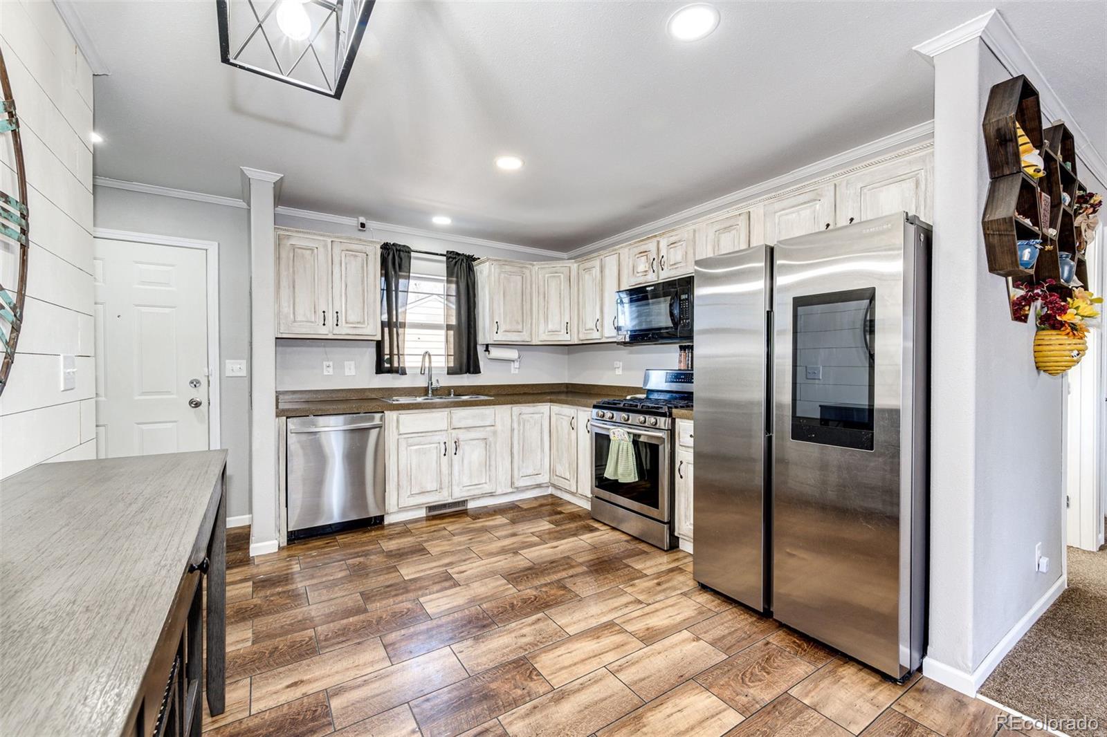 570 4th Street Bennett, CO 80102 - Photo 11 of 36 a kitchen with granite countertop a refrigerator and a sink