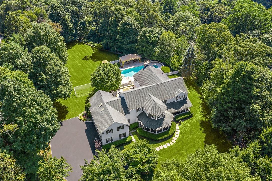 an aerial view of a house with a swimming pool a yard and a garage