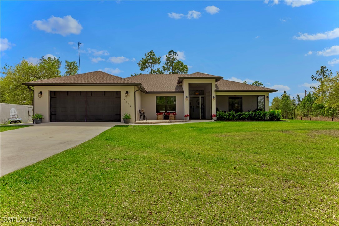 7583 18th Place LaBelle, FL 33935 - Photo 1 of 36 a front view of a house with a yard