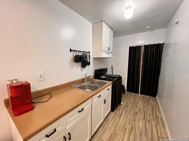 a kitchen with granite countertop a refrigerator stove and sink