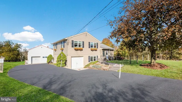 a view of a house with a yard and pathway