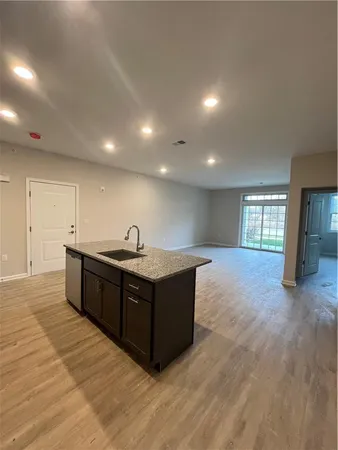a kitchen with stainless steel appliances granite countertop a sink and a large window
