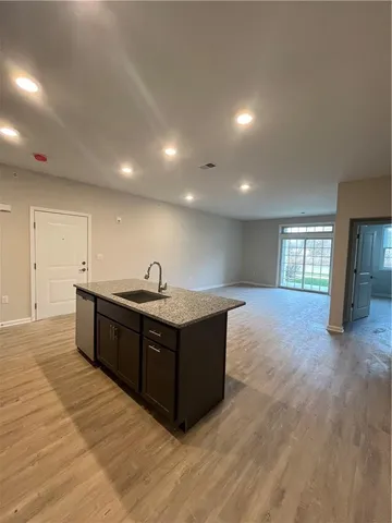 a kitchen with stainless steel appliances granite countertop a sink and a large window