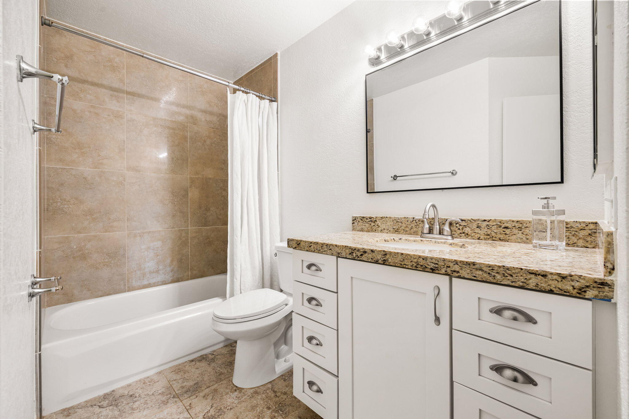 48255 Monroe Street, Unit 59 Indio, CA 92201 - Photo 16 of 58 a bathroom with a granite countertop sink a toilet and a bathtub