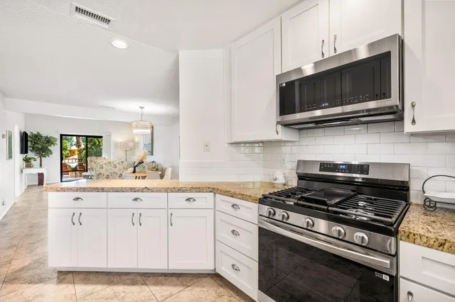 a kitchen with stainless steel appliances a sink a stove and microwave