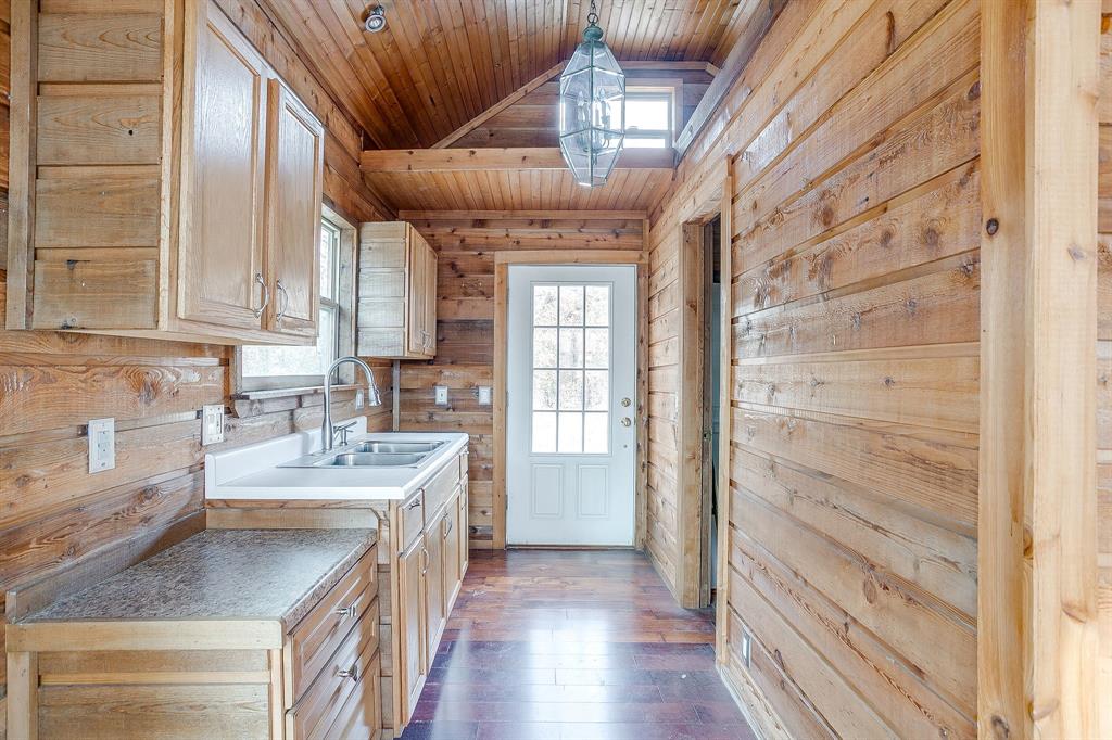 2780 Pear Orchard Road Granbury, TX 76048 - Photo 39 of 40 a kitchen with a sink a stove cabinets and a wooden floor