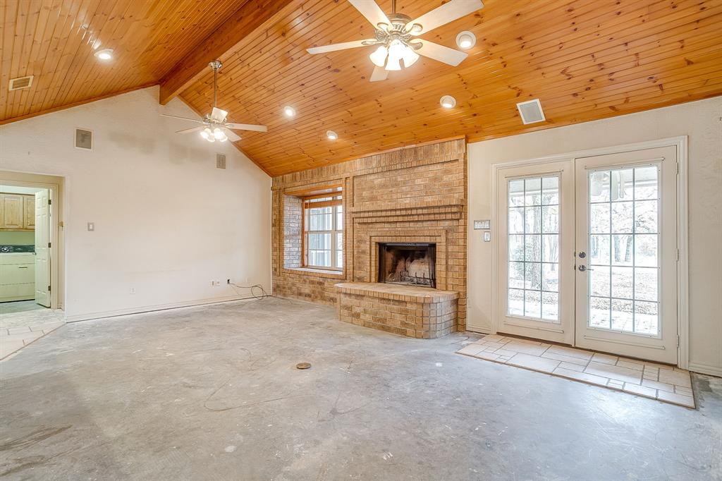 2780 Pear Orchard Road Granbury, TX 76048 - Photo 9 of 40 a view of an empty room with a fireplace and a window