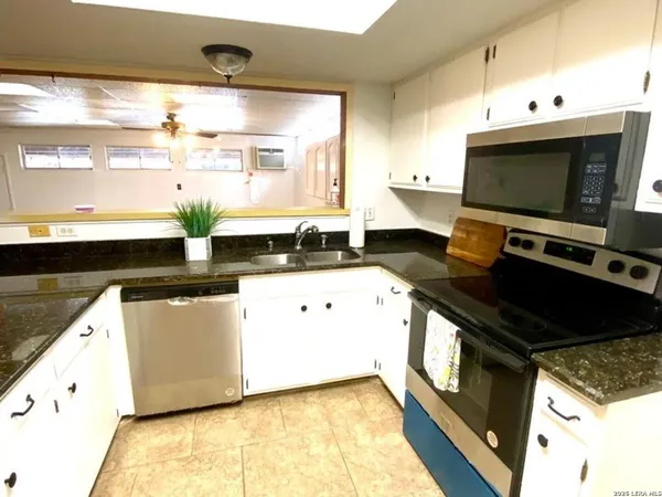 a kitchen with stainless steel appliances a stove a sink and a microwave