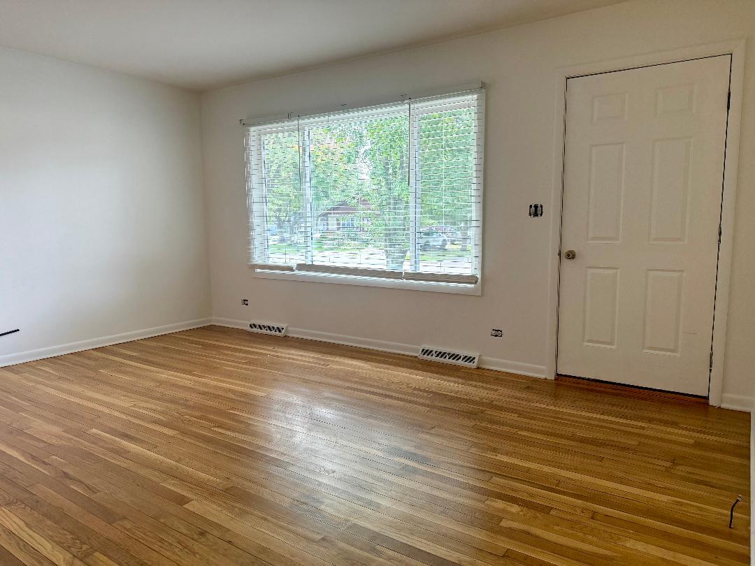 1622 Oak Lane, Unit 2 Sycamore, IL 60178 - Photo 3 of 5 a view of an empty room with wooden floor and a window