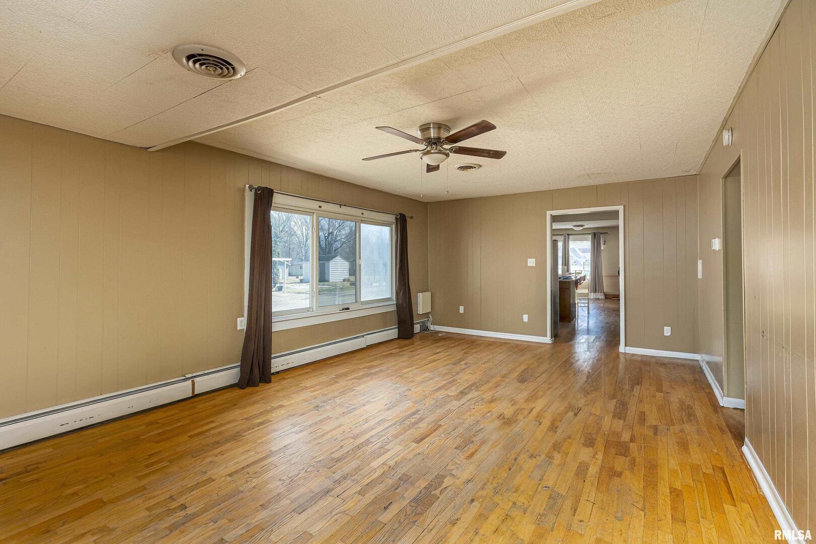 1500 West Tyler Street Herrin, IL 62948 - Photo 3 of 17 a view of an empty room with window and wooden floor