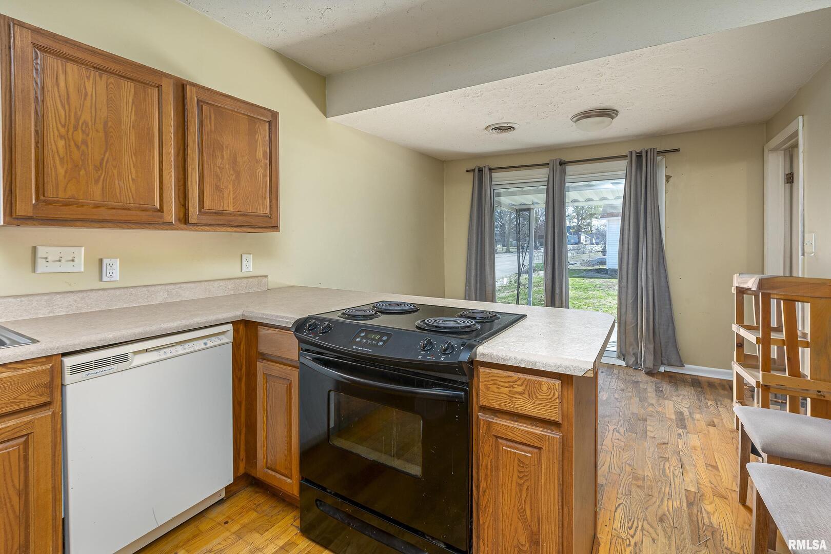 1500 West Tyler Street Herrin, IL 62948 - Photo 6 of 17 a kitchen with granite countertop a stove a sink and a refrigerator