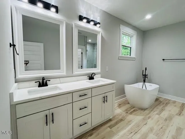 a bathroom with a granite countertop sink mirror and bathtub