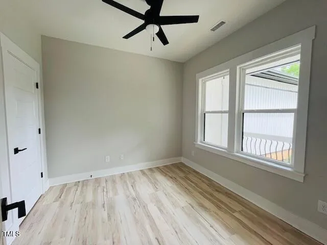 a view of a room with wooden floor and windows