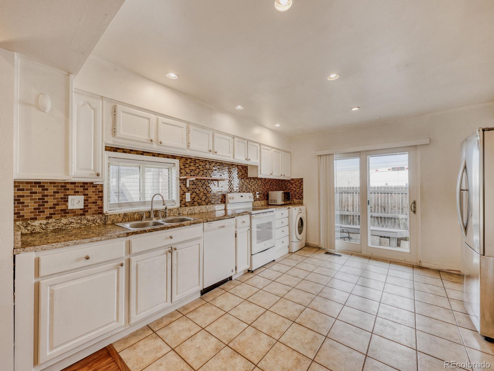 6495 East Happy Canyon Road, Unit 43 Denver, CO 80237 - Photo 14 of 28 a kitchen with granite countertop a refrigerator and cabinets