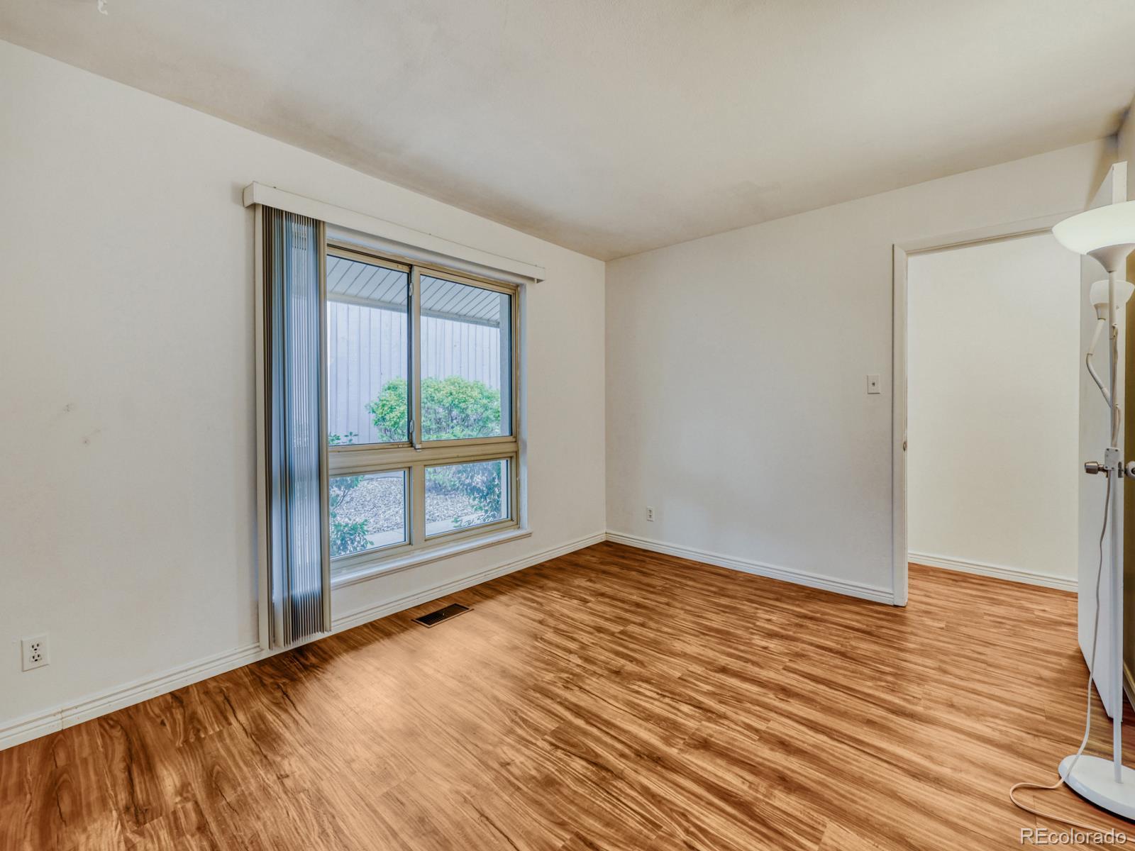 6495 East Happy Canyon Road, Unit 43 Denver, CO 80237 - Photo 19 of 28 a view of an empty room with wooden floor and a window