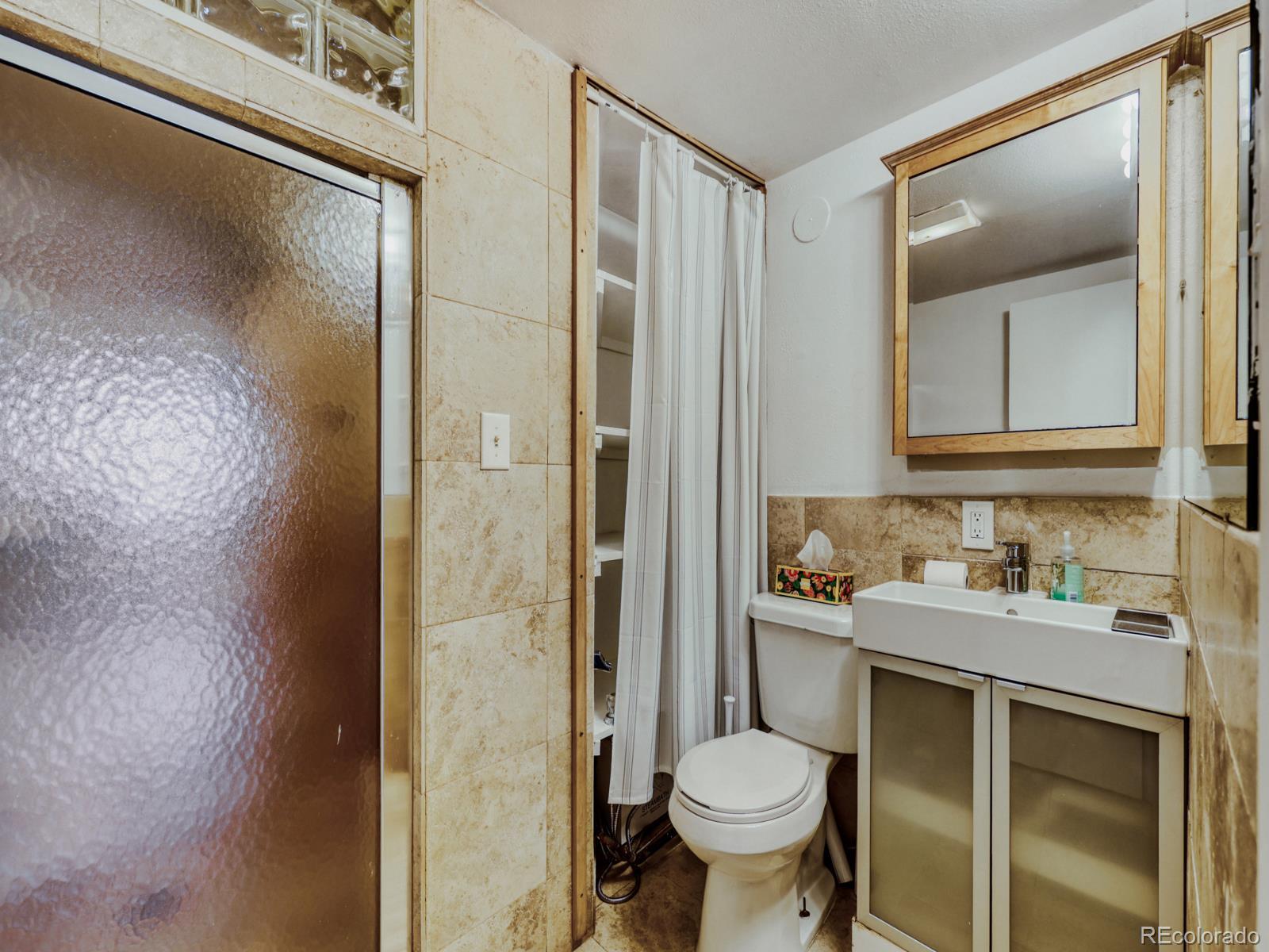 6495 East Happy Canyon Road, Unit 43 Denver, CO 80237 - Photo 21 of 28 a bathroom with a sink toilet and shower