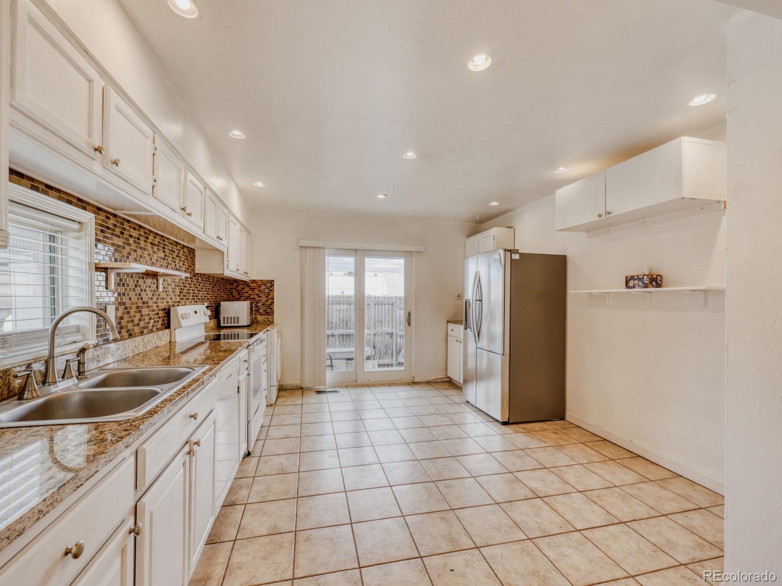 6495 East Happy Canyon Road, Unit 43 Denver, CO 80237 - Photo 7 of 28 a kitchen with a sink a refrigerator and cabinets