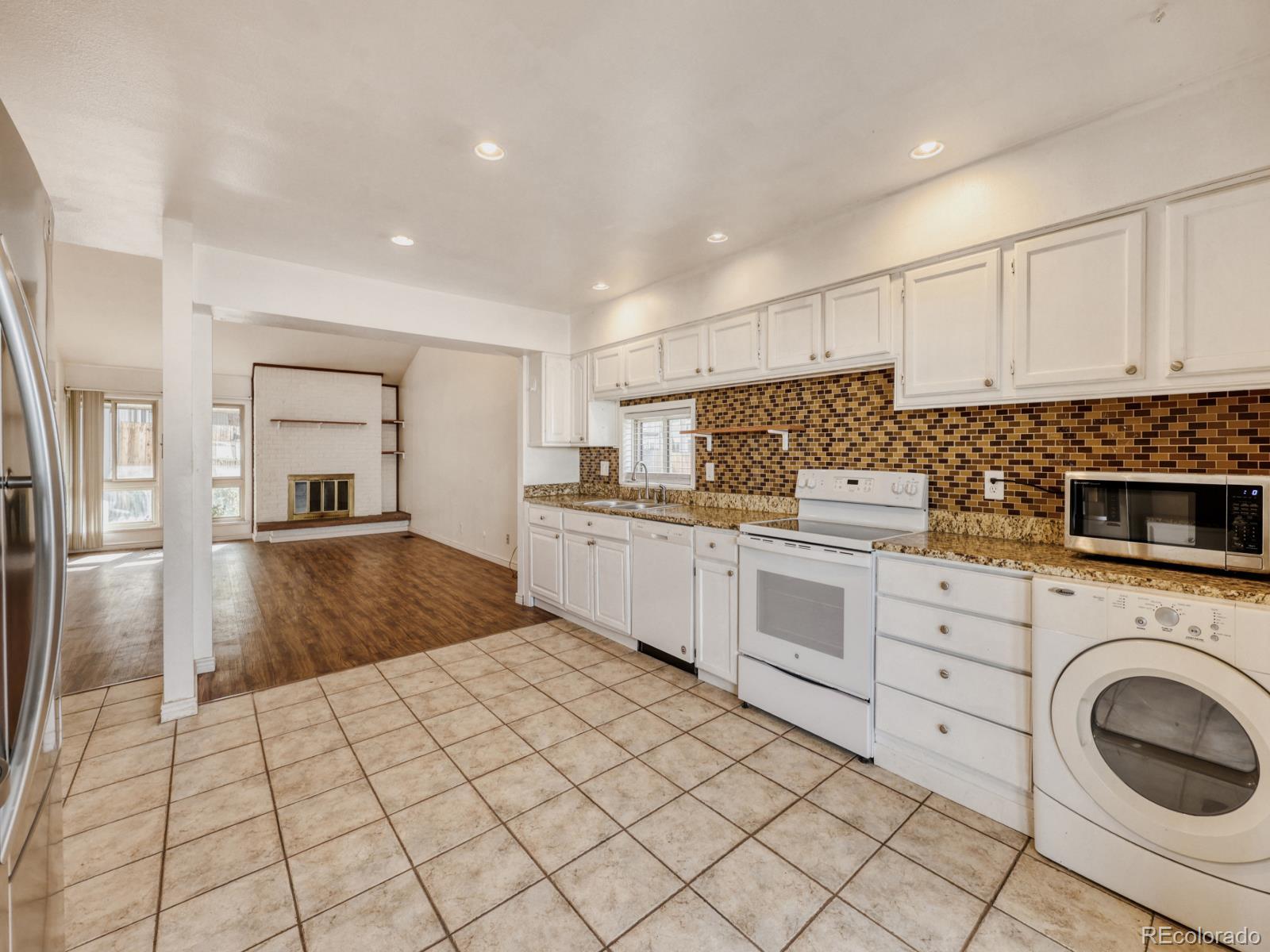 6495 East Happy Canyon Road, Unit 43 Denver, CO 80237 - Photo 8 of 28 a kitchen with white cabinets and white appliances