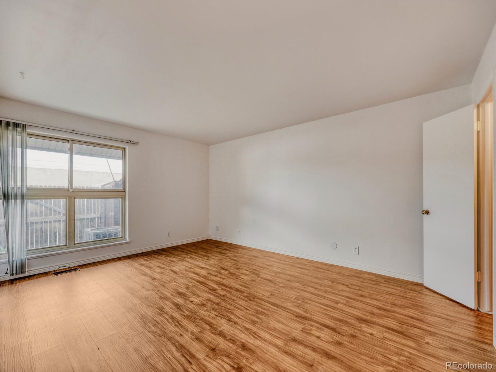 6495 East Happy Canyon Road, Unit 43 Denver, CO 80237 - Photo 9 of 28 wooden floor in an empty room with a window