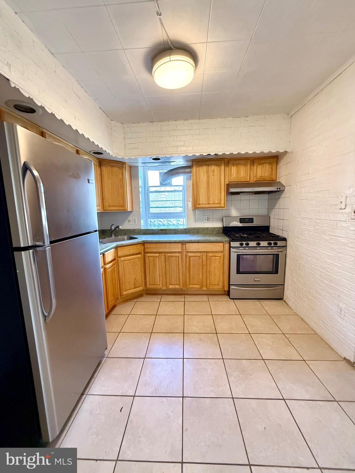 403 South Main Street Ambler, PA 19002 - Photo 10 of 37 a kitchen with granite countertop a refrigerator and a stove top oven